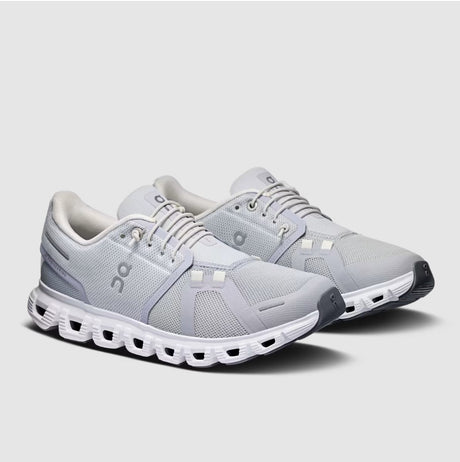 Gray running shoes with white sole on a light gray background