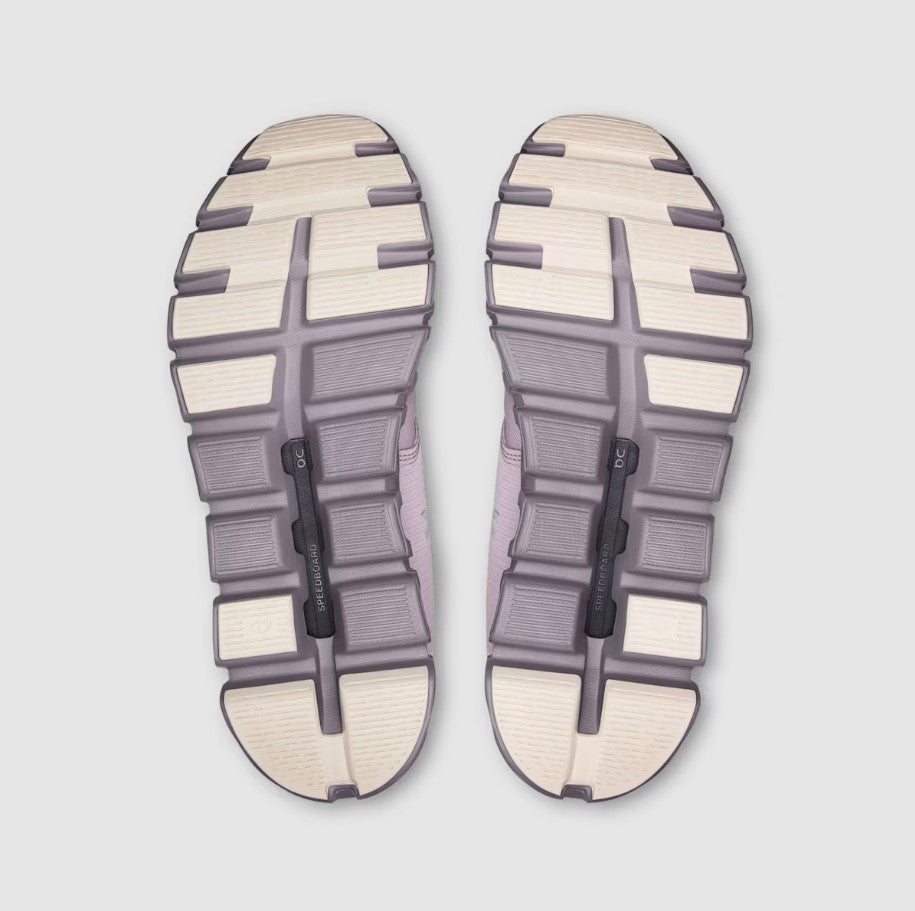 bottom view of mauve and beige shoe soles on a light gray background