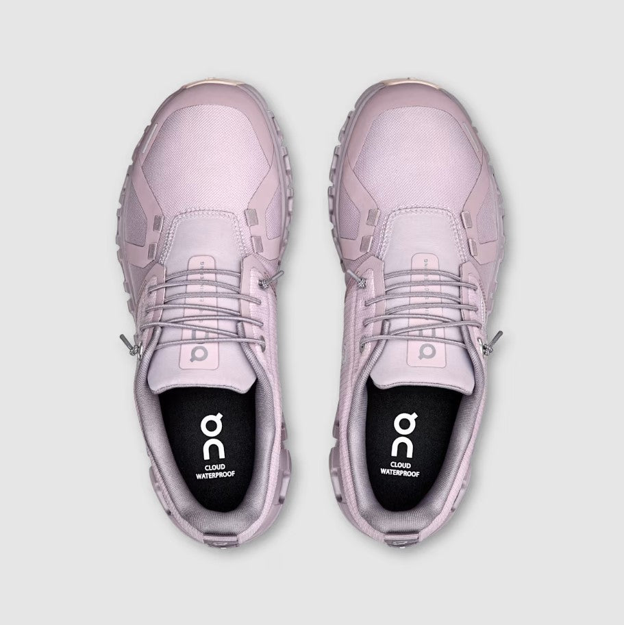 Pair of pink sneakers with 'on' branding on a light gray background