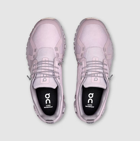 Pair of pink sneakers with 'on' branding on a light gray background