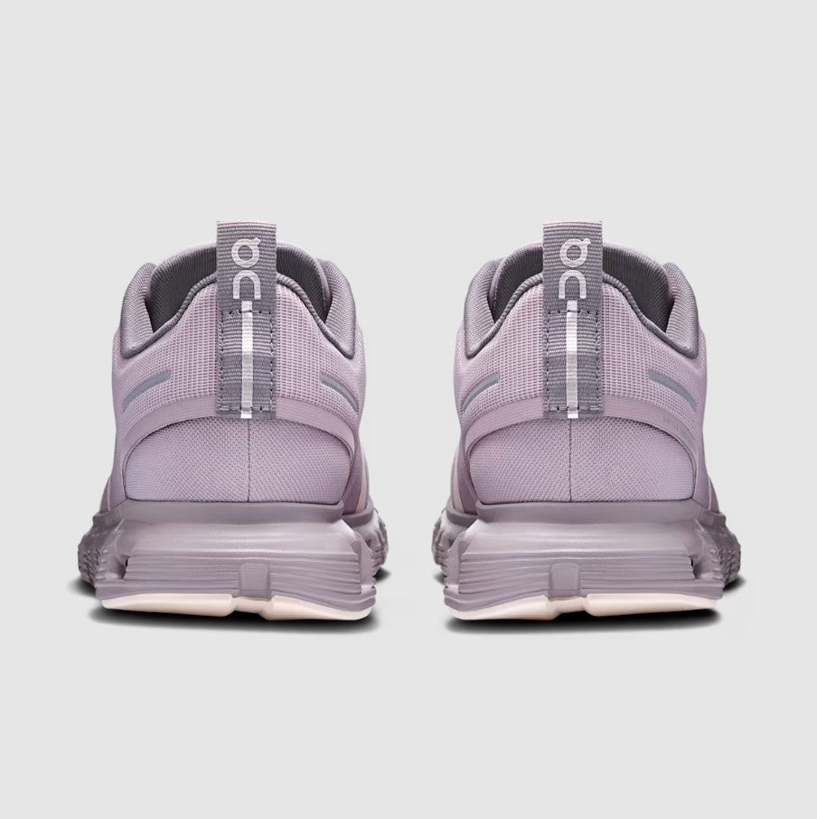 Pair of purple running shoes with visible 'On' branding on a light gray background