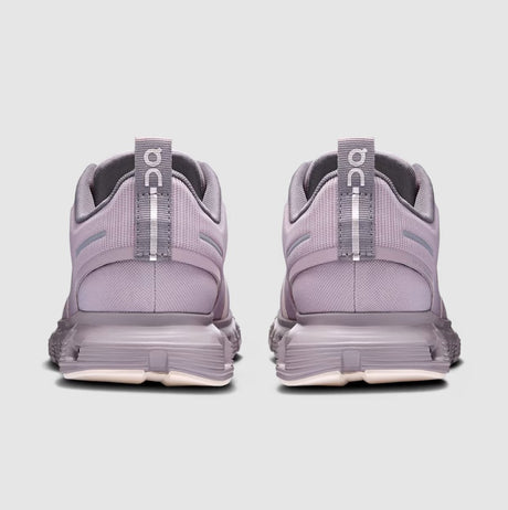 Pair of purple running shoes with visible 'On' branding on a light gray background