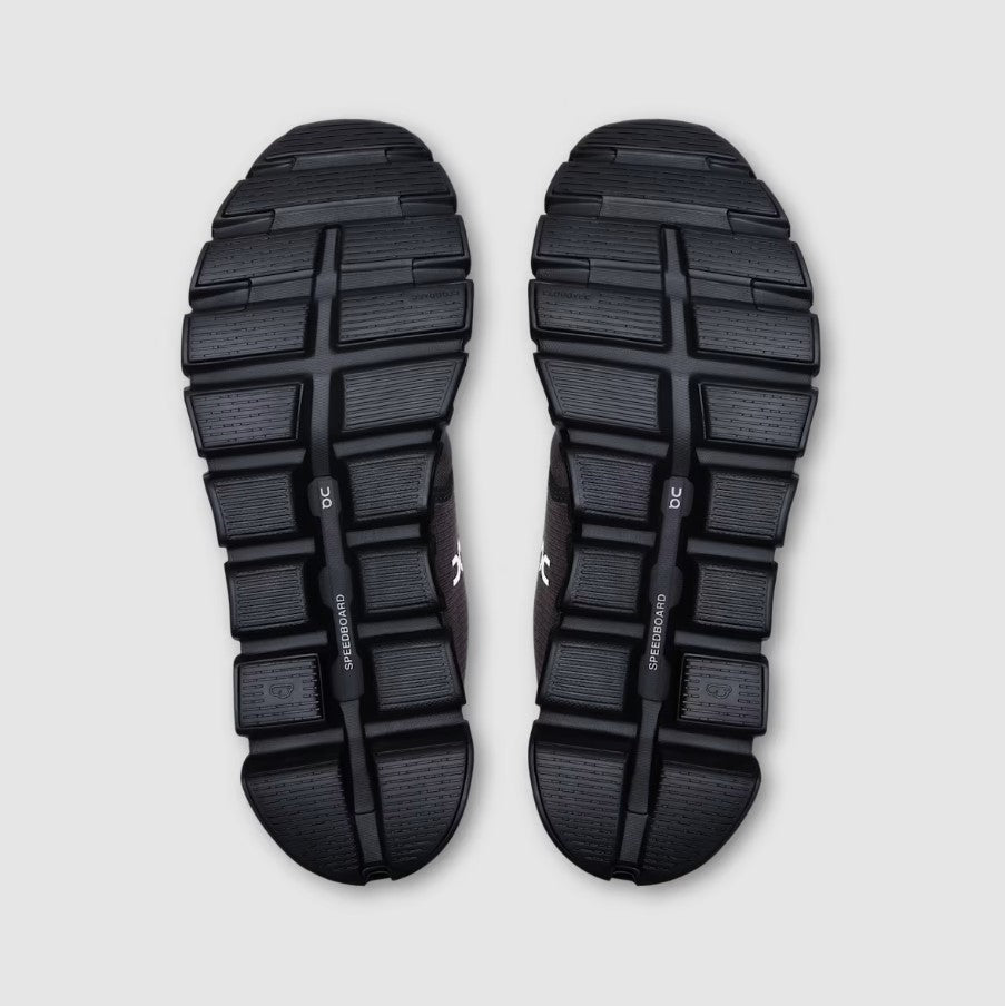 Black athletic shoes with sole pattern on a light gray background