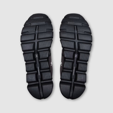 Black athletic shoes with sole pattern on a light gray background