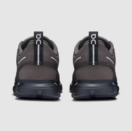 Pair of gray running shoes with visible 'On' branding on a light gray background