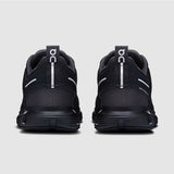 Black athletic shoes with visible branding on a light gray background