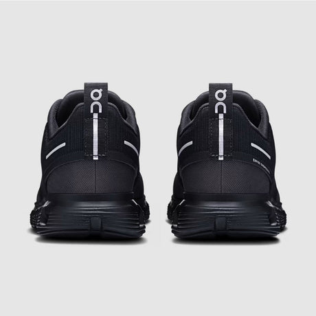 Black athletic shoes with visible branding on a light gray background