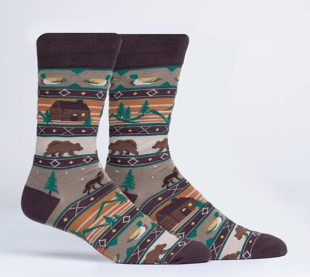 Socks with a nature-themed pattern featuring bears, cabins, and trees on a white background.