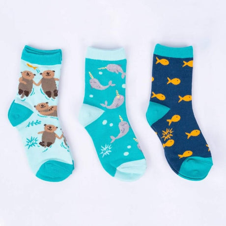 Three pairs of socks with animal patterns, including otters, narwhales and goldfish on a white background