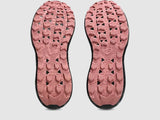 Close-up of pink shoe soles with tread pattern on a light gray background