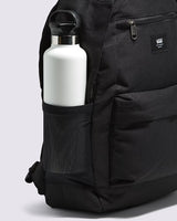 Black backpack with a white water bottle in a side pocket on a light gray background