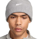 Person wearing a gray knit beanie with a Nike logo on a white background