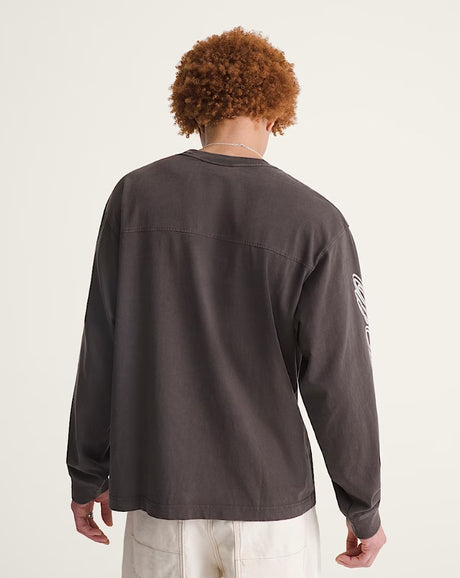 Person wearing a blackish - brown long-sleeve shirt with a plain back, standing against a plain background.