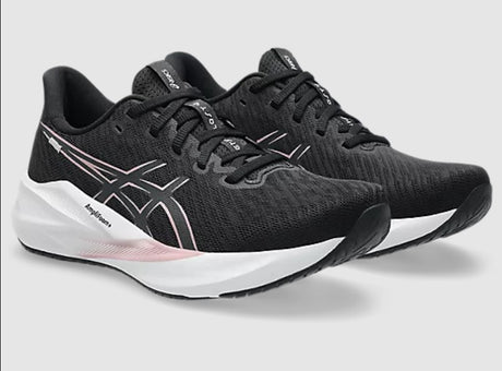 Black running shoes with white sole on a light gray background