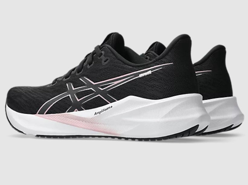 Black running shoes with white sole on a gray background