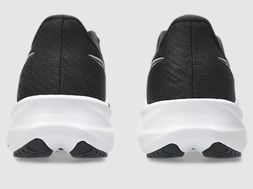 Black running shoes with white soles on a light gray background